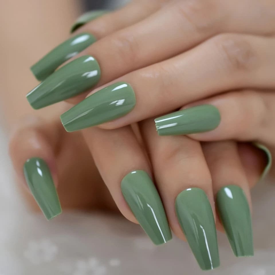 Elegant sage green press-on nails in an almond shape paired with gold jewelry and neutral fashion accessories-surethings