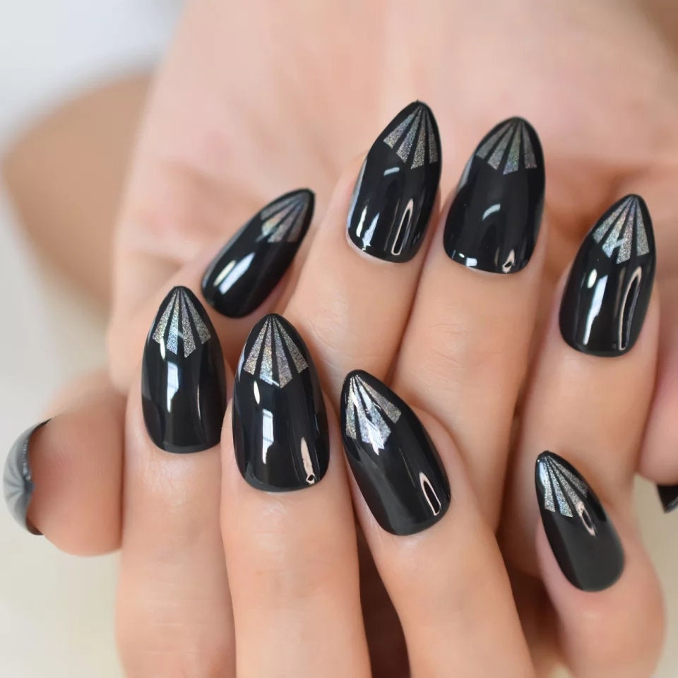 A hand showcasing glossy black almond nails with a minimalist aesthetic, perfect for trendy manicure inspiration