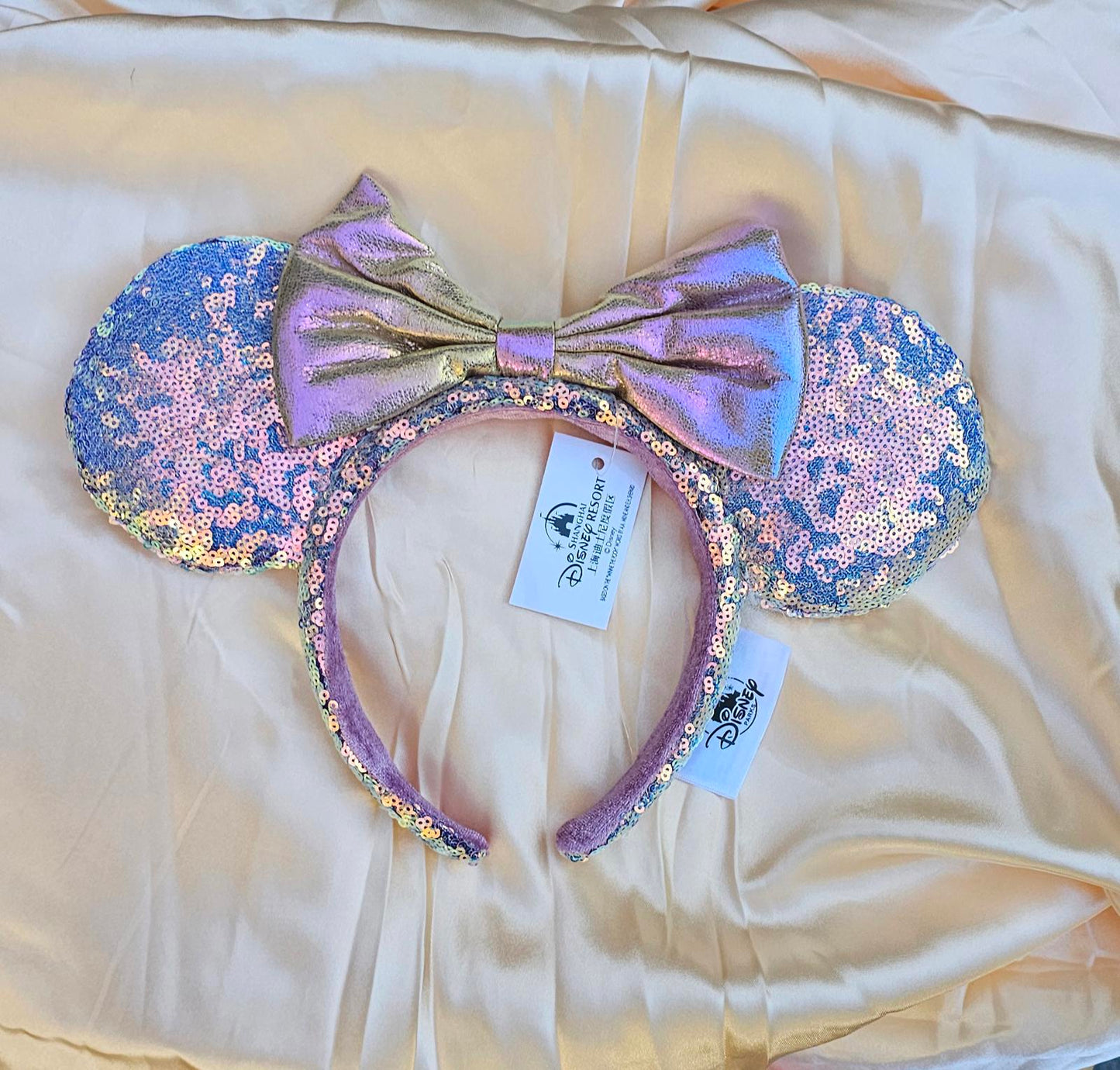 Close-up of Holographic Pink Gold Sequin Minnie Ears Disney Parks headband with iridescent Mickey Mouse Pink bow and shimmering sequins surethings