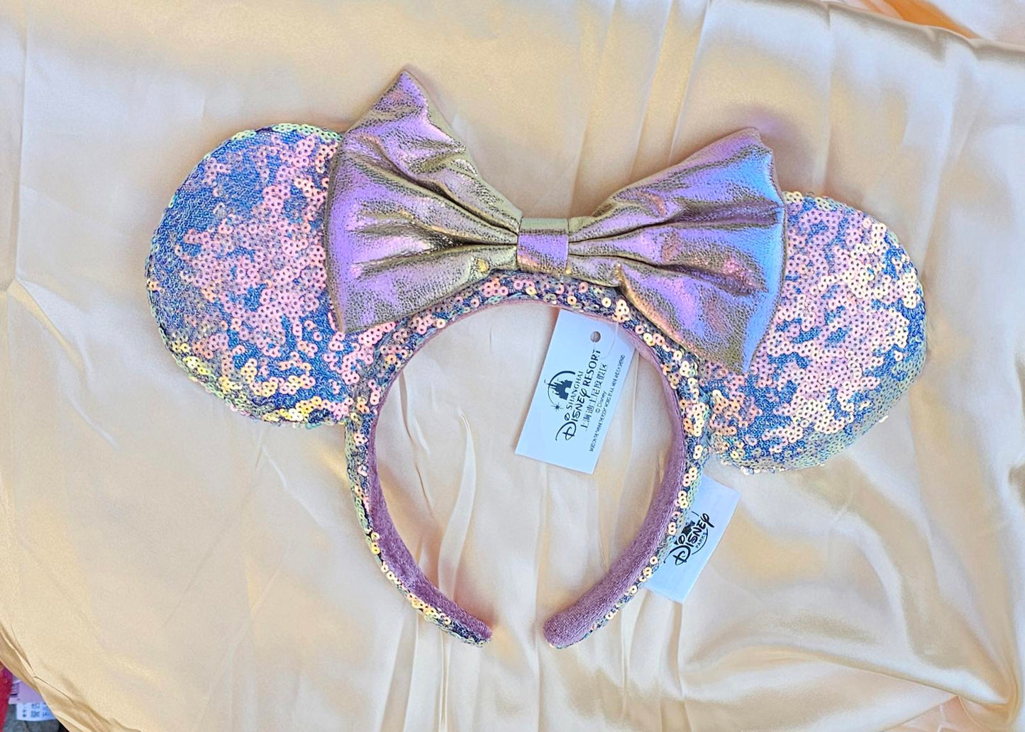 Close-up of Holographic Pink Gold Sequin Minnie Ears Disney Parks headband with iridescent Mickey Mouse Pink bow and shimmering sequins surethings